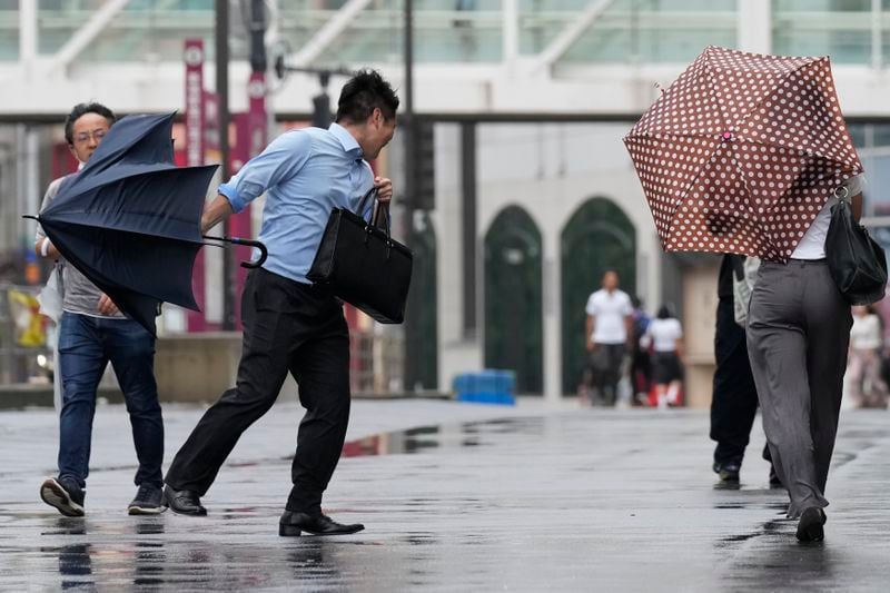 A man holding umbrella struggles with strong wind as Typhoon Ampil approaches Tokyo area, Japan, Friday, Aug. 16, 2024. (AP Photo/Hiro Komae)