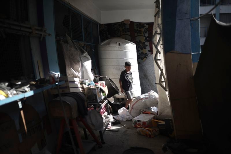 A Palestinian child navigates heavy damage to a UNRWA school sheltering displaced persons the day after a nearby house was targeted by Israeli bombardment in Khan Younis, southern Gaza Strip, Friday, June 21, 2024. (AP Photo /Jehad Alshrafi)