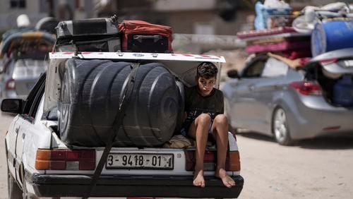 A Palestinian child rides in the trunk of a car as he evacuates Maghazi refugee camp in the central Gaza Strip, as part of a mass evacuation ordered by the Israeli military ahead of an operation, Saturday, Aug. 17, 2024. (AP Photo/Abdel Kareem Hana)