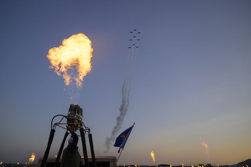 A fly-over by The Chili Flight Team, and a candlelight burn by balloon teams followed the national anthem during he 52nd Albuquerque International Balloon Fiesta in Albuquerque, N.M., on Saturday, Oct. 5, 2024. (AP Photo/Roberto E. Rosales)