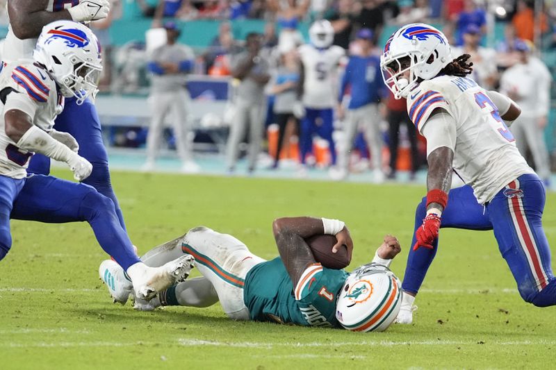 Miami Dolphins quarterback Tua Tagovailoa (1) falls in the field after colliding with Buffalo Bills safety Damar Hamlin (3) during the second half of an NFL football game, Thursday, Sept. 12, 2024, in Miami Gardens, Fla. (AP Photo/Rebecca Blackwell)