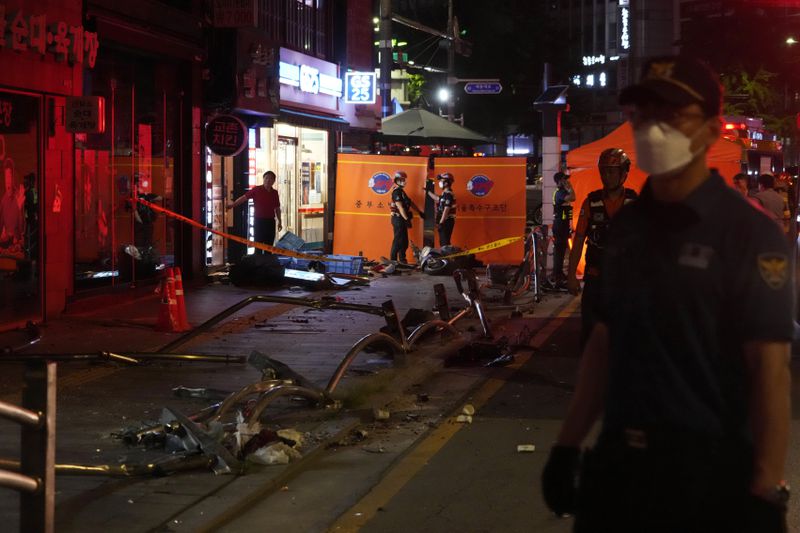 Police officers control a car accident scene near Seoul City Hall in downtown Seoul, South Korea, Monday, July 1, 2024. A car hit pedestrians waiting at a traffic light in central Seoul on Monday evening, killing nine people and injuring four, South Korea's emergency officials said. (AP Photo/Ahn Young-joon)