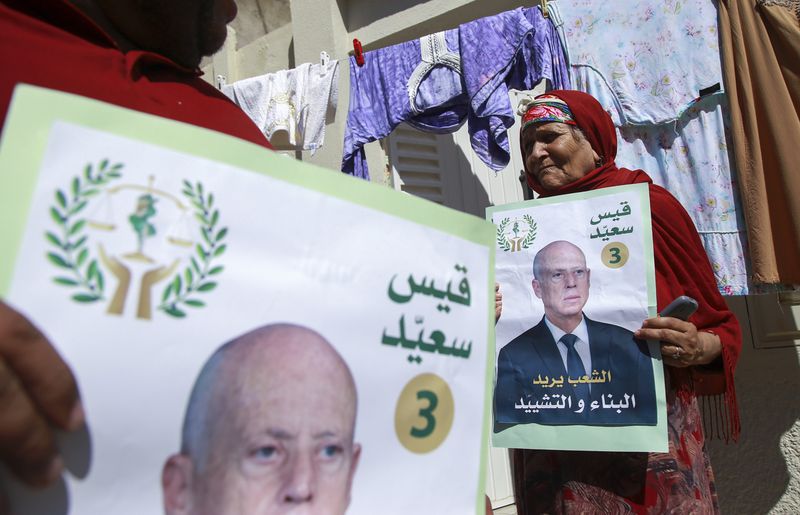 Supporters of Tunisian President and candidate for re-election Kais Saied meet with residents of a neighbourhood during a campaign tour, in Ariana, Tunisia, Thursday, Sept. 26, 2024. (AP Photo/Anis Mili)