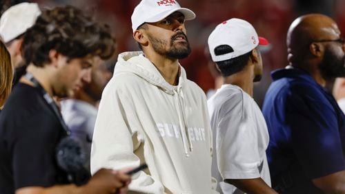 Atlanta Hawks NBA basketball player Trae Young, center left, watches as Oklahoma plays Houston during the second half of an NCAA college football game Saturday, Sept. 7, 2024, in Norman, Okla. (AP Photo/Alonzo Adams)