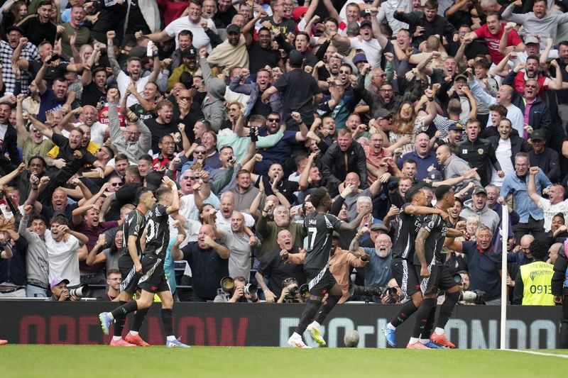 Arsenal's Gabriel, right, celebrates with teammates after scoring the opening goal during the English Premier League soccer match between Tottenham Hotspur and Arsenal in London, Sunday, Sept. 15, 2024. (AP Photo/Kin Cheung)