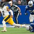 Pittsburgh Steelers quarterback Justin Fields (2) scrambles past a tackle-attempt by Indianapolis Colts defensive end Tyquan Lewis, lower right, during the second half of an NFL football game Sunday, Sept. 29, 2024, in Indianapolis. (AP Photo/Darron Cummings)