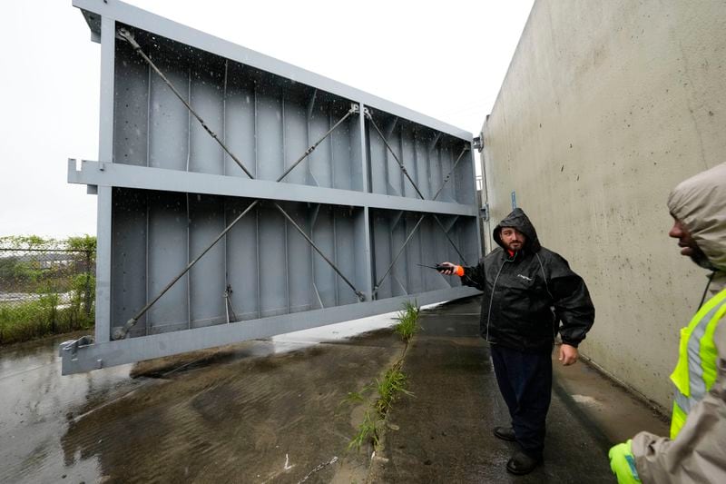 Workers from the Southeast Louisiana Flood Protection Authority-West close floodgates along the Harvey Canal, just outside the New Orleans city limits, in anticipation of Tropical Storm Francine, in Harvey, La., Tuesday, Sept. 10, 2024. (AP Photo/Gerald Herbert)