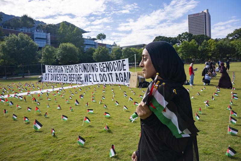 Aleena Noor, a first-year industrial engineering major and member of the Muslim Student Association, poses with flags she is placing in honor of those who lost their lives in the Israel-Hamas war at a memorial on the Georgia Tech campus green on Tuesday, Aug. 20, 2024. (Olivia Bowdoin for the Atlanta Journal-Constitution)