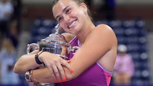 Aryna Sabalenka, of Belarus, poses for photos with the championship trophy after defeating Jessica Pegula, of the United States, in the women's singles final of the U.S. Open tennis championships, Saturday, Sept. 7, 2024, in New York. (AP Photo/Frank Franklin II)