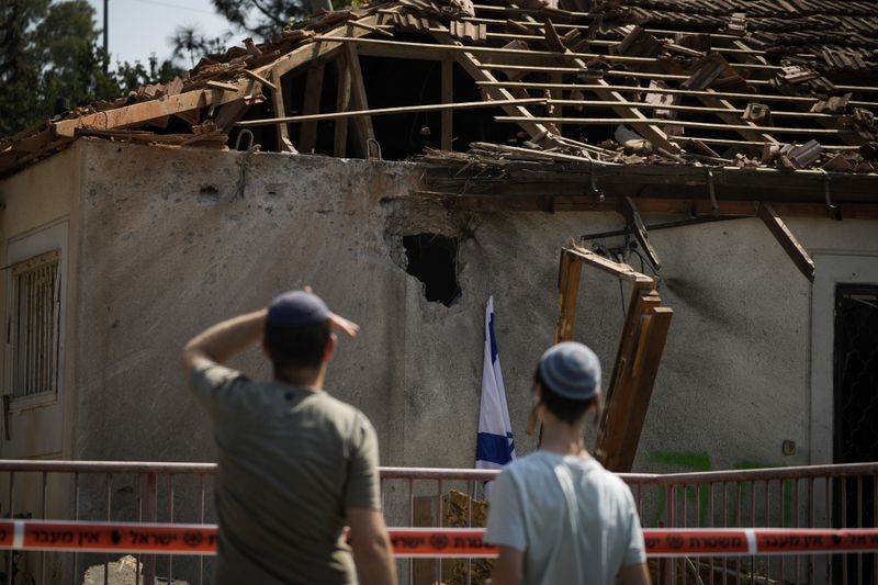 People look at a damaged house that was hit by a rocket fired from Lebanon, near Safed, northern Israel, on Wednesday, Sept. 25, 2024. (AP Photo//Leo Correa)