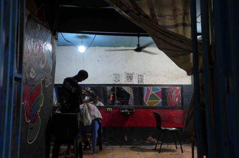 A barber gives a haircut in Dili, East Timor, Sunday, Sept. 8, 2024. (AP Photo/Firdia Lisnawati)