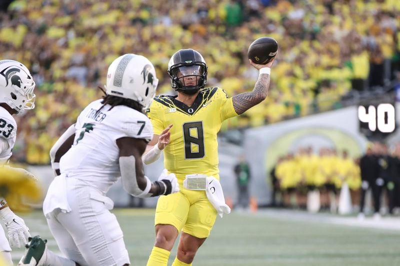 Oregon quarterback Dillon Gabriel (8) throws past Michigan State linebacker Jordan Turner (7) during the first half of an NCAA college football game, Friday, Oct. 4, 2024, in Eugene, Ore. (AP Photo/Amanda Loman)