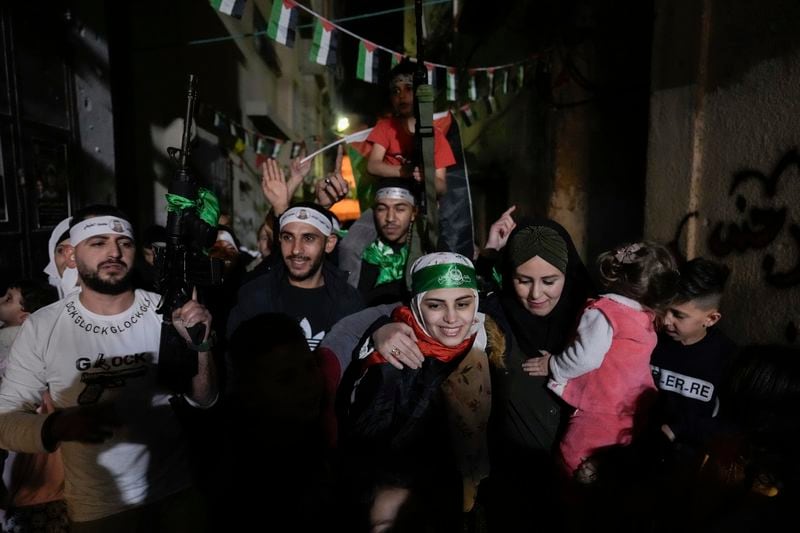 Aseel al-Titi, wearing a Hamas headband, a former Palestinian prisoner who was released by the Israeli authorities, is greeted by friends and family members in Balata, a Palestinian refugee camp in Nablus, West Bank, Friday, Nov. 24, 2023. (AP Photo/Majdi Mohammed)