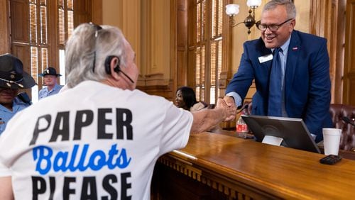 State Election Board Executive Director Mike Coan greets an election skeptic after a hastily planned State Election Board meeting at the Capitol in Atlanta on Friday. (Arvin Temkar / AJC)