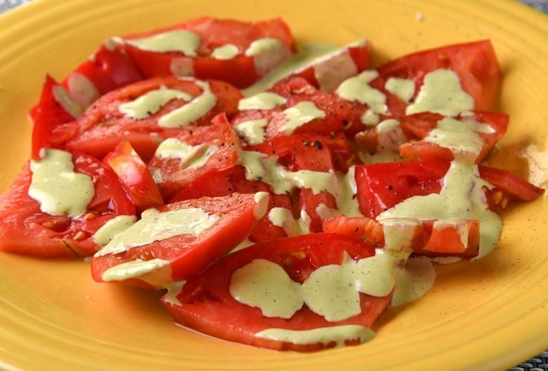 Nick Melvin's Poco Goddess Verde is drizzled over ripe tomato slices. Melvin also enjoys the condiment as a salad dressing and a dip. Styling by Nick Melvin. (CHRIS HUNT FOR THE ATLANTA JOURNAL-CONSTITUTION)