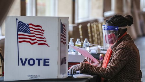 A poll worker sorts through voting material on Nov. 3, 2020, at Park Tavern in Atlanta. (John Spink/AJC)