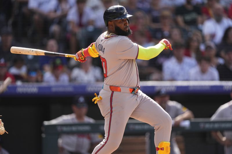 Atlanta Braves' Marcell Ozuna singles off Colorado Rockies pitcher Victor Vodnik in the ninth inning of a baseball game Sunday, Aug. 11, 2024, in Denver. (AP Photo/David Zalubowski)