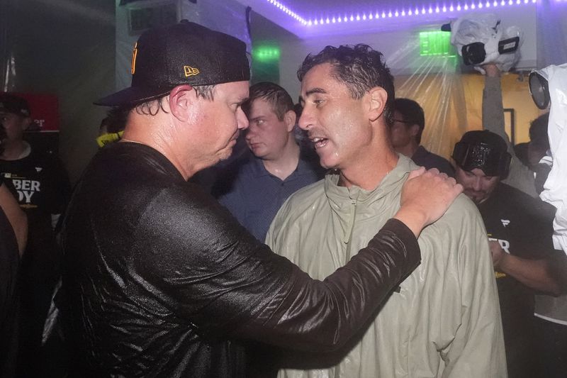 San Diego Padres manager Mike Shildt, left, celebrates with general manager A.J. Preller after the Padres clinched a playoff spot with a triple play to end their baseball game against the Los Angeles Dodgers, Tuesday, Sept. 24, 2024, in Los Angeles. (AP Photo/Mark J. Terrill)