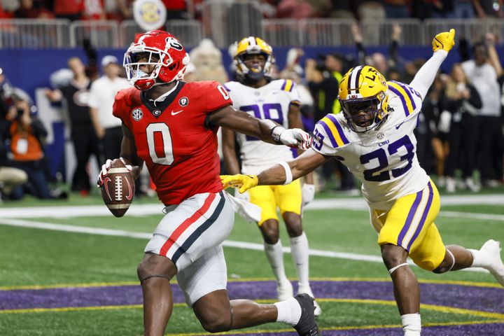 Georgia Bulldogs tight end Darnell Washington (0) scores a touchdown ahead of LSU Tigers linebacker Micah Baskerville (23) during the second half of the SEC Championship Game at Mercedes-Benz Stadium in Atlanta on Saturday, Dec. 3, 2022. (Bob Andres / Bob Andres for the Atlanta Constitution)