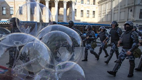 FILE - Police officers walk past a balloon seller as they control a street during an unsanctioned rally in front of the Russian General Prosecution building in Moscow, Saturday, July 27, 2019. The Russian prosecutor general's office has declared The Moscow Times newspaper to be an "undesirable organization." The designation means the newspaper popular with those in Russia's expatriate community must stop any work in Russia. (AP Photo/Alexander Zemlianichenko, File)