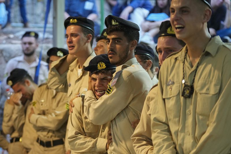 Israeli Navy sailors mourn during the funeral of Petty Officer 1st Class David Moshe Ben Shitrit, who was killed on a Hezbollah attack, at the Mount Herzl military cemetery in Jerusalem, Sunday, Aug. 25, 2024. (AP Photo/Ohad Zwigenberg)