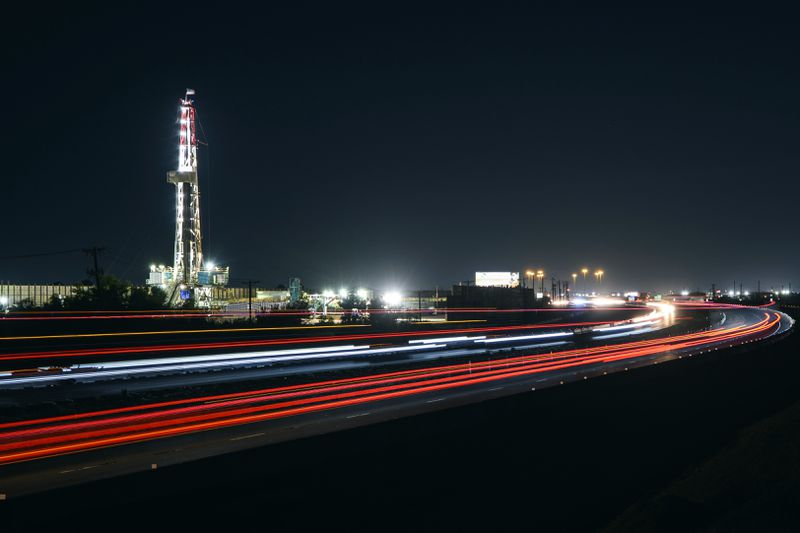 FILE - Motorists drive past an oil rig set up alongside Interstate 20, July 7, 2022, in Midland, Texas. (Eli Hartman/Odessa American via AP, File)