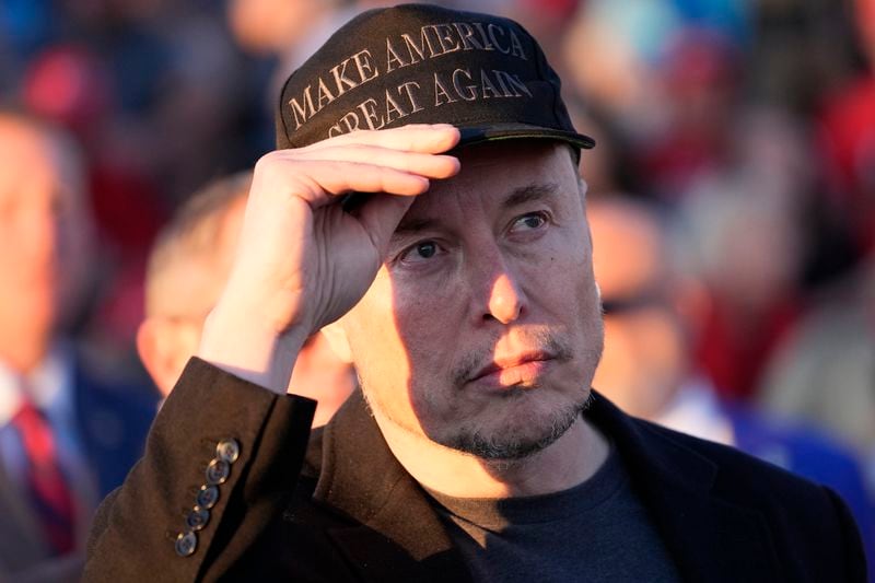 Tesla and SpaceX CEO Elon Musk listens as Republican presidential nominee former President Donald Trump speaks at a campaign event at the Butler Farm Show, Saturday, Oct. 5, 2024, in Butler, Pa. (AP Photo/Alex Brandon)