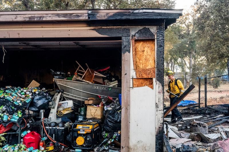 Firefighter Nolan Graham works to extinguish a smoldering garage as the Boyles fire burns in Clearlake, Calif., on Sunday, Sept. 8, 2024. (AP Photo/Noah Berger)