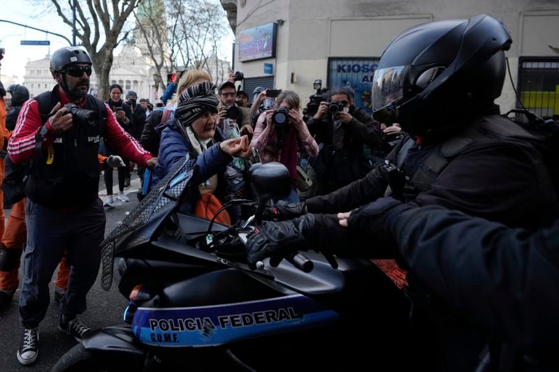 A woman scolds the police during protests against President Javier Milei's veto of a pension raise in Buenos Aires, Argentina, Wednesday, Sept. 11, 2024. (AP Photo/Natacha Pisarenko)