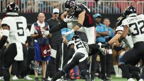 Atlanta Falcons tight end John FitzPatrick (87) leaps over Jacksonville Jaguars safety Antonio Johnson (26) after a catch by FitzPatrick during the first half at Mercedes-Benz Stadium, on Friday, Aug. 23, 2024, in Atlanta. (Jason Getz / AJC)