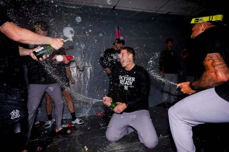 New York Yankees' Anthony Rizzo, center, celebrates clinching a playoff spot with teammates after a 2-1 win in 10 innings over the Seattle Mariners in a baseball game Wednesday, Sept. 18, 2024, in Seattle. (AP Photo/Lindsey Wasson)