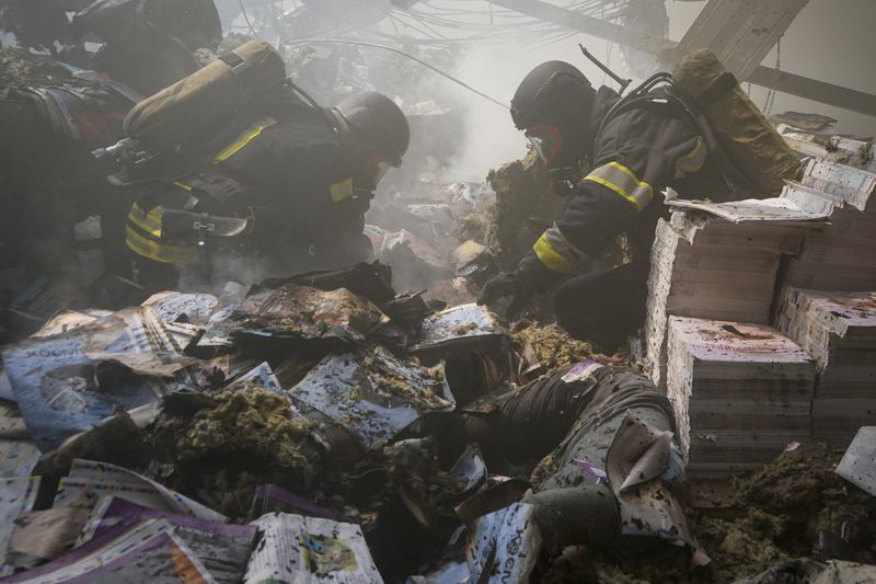 Firefighters recover bodies from under the rubble after a Russian missile hit a large printing house in Kharkiv, Ukraine, Thursday, May 23, 2024. Russian missiles slammed into Ukraine’s second-largest city in the northeast of the country and killed at least seven civilians early Thursday, officials said, as Kyiv’s army labored to hold off an intense cross-border offensive by the Kremlin’s larger and better-equipped forces. (AP Photo/Andrii Marienko)