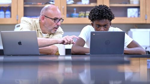 History teacher Matt Brophy, left, works with Flerentin “Flex” Jean-Baptiste, 16, of Medford, Mass., on making up late assignments during summer school at Medford High School, Friday, Aug. 2, 2024, in Medford. (AP Photo/Josh Reynolds)