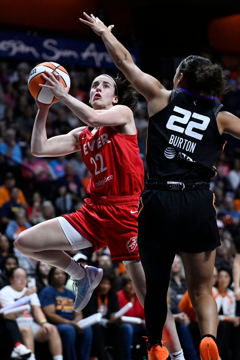 Indiana Fever guard Caitlin Clark, left, shoots as Connecticut Sun guard Veronica Burton defends, during a first-round WNBA basketball playoff game, Wednesday, Sept. 25, 2024, in Uncasville, Conn. (AP Photo/Jessica Hill)