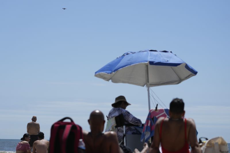 A drone scans the shoreline for signs of struggling swimmers, sharks and other hazards at Rockaway Beach in New York, Thursday, July 11, 2024. A fleet of drones patrolling New York City’s beaches for signs of sharks and struggling swimmers is drawing backlash from an aggressive group of seaside residents: local shorebirds. Since the drones began flying in May, flocks of birds have repeatedly swarmed the devices, forcing the police department and other city agencies to adjust their flight plans. (AP Photo/Seth Wenig)