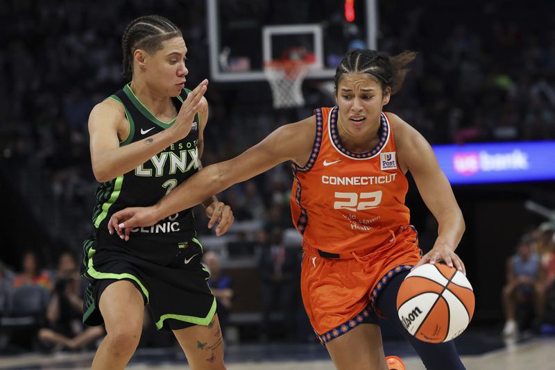 Connecticut Sun guard Veronica Burton (22) controls the ball against Minnesota Lynx guard Natisha Hiedeman (2) during the second half of Game 1 of a WNBA basketball semifinals series Sunday, Sept. 29, 2024, in Minneapolis. (AP Photo/Stacy Bengs)