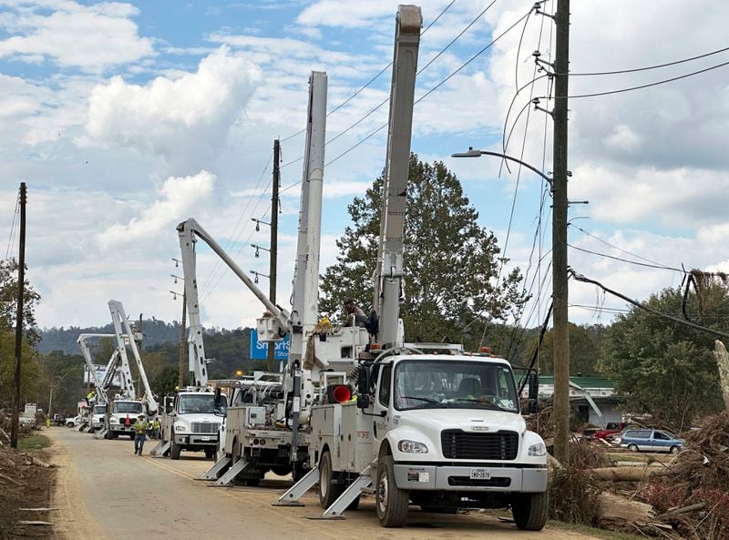 Contractors for Duke Energy rebuild destroyed electrical lines near the Swannanoa River in Asheville, N.C., Friday, Oct. 4, 2024. (AP Photo/Jeff Amy)