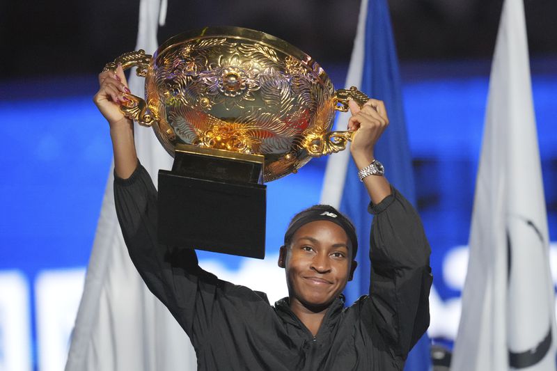 Coco Gauff of the United States celebrates with the championship trophy after defeating Karolina Muchova of Czech Republic in the women's singles final match at the China Open tennis tournament at the National Tennis Center in Beijing, Sunday, Oct. 6, 2024. (AP Photo/Achmad Ibrahim)