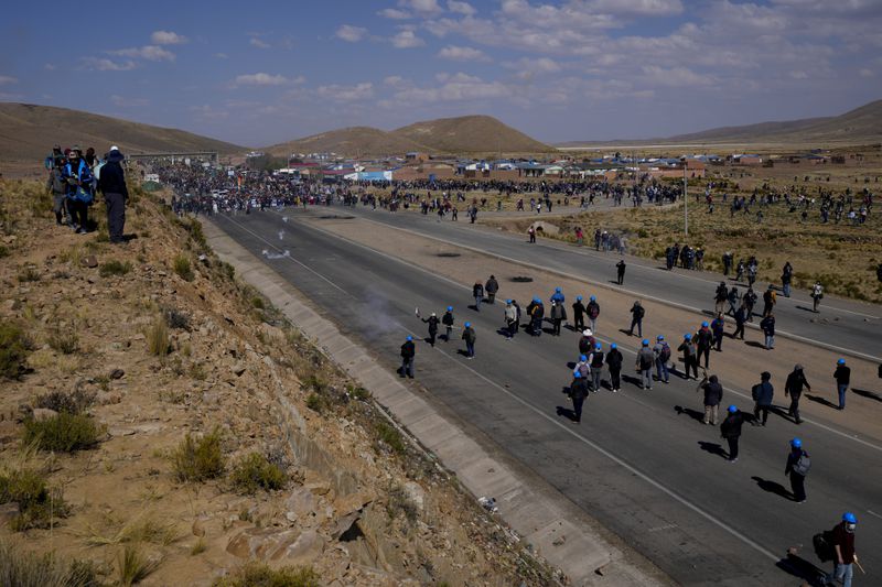 Supporters of former President Evo Morales, top, who are marching to the capital to protest the government of current President Luis Arce, are confronted by Arce supporters, below, in Vila Vila, Bolivia, Tuesday, Sept. 17, 2024. (AP Photo/Juan Karita)