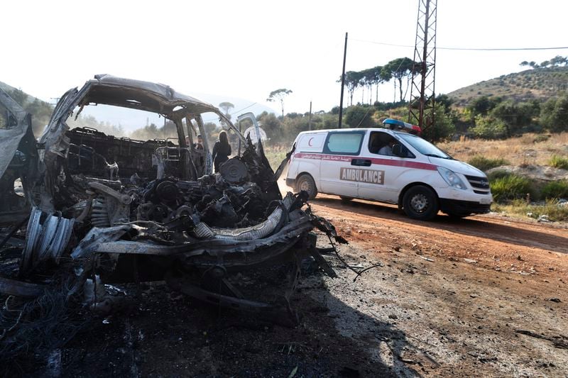 An ambulance drives past a vehicle that burned in the town of Masyaf, Syria, Monday, Sept. 9, 2024. Syrian state news agency SANA says that Israeli strikes hit several areas in central Syria Sunday night, damaging a highway in Hama province and sparking fires. (AP Photo/Omar Sanadiki)