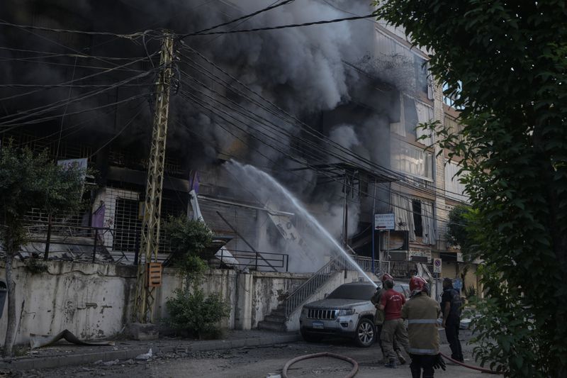 Firefighters extinguish a fire at the site of an Israeli airstrike in Dahiyeh, Beirut, Lebanon, Sunday, Oct. 6, 2024. (AP Photo/Bilal Hussein)