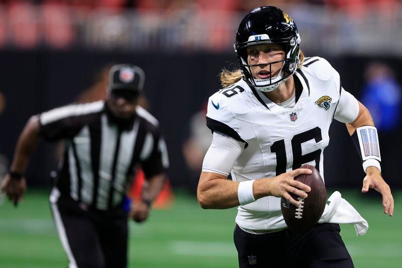 Jacksonville Jaguars quarterback Trevor Lawrence (16) runs out of the pocket against the Atlanta Falcons in the first half of an NFL preseason footballl game, Friday, Aug. 23, 2024, in Atlanta. (AP Photo/Butch Dill)