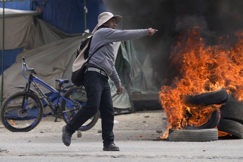 A supporter of former President Evo Morales, protesting the government of current President Luis Arce, clashes with Arce supporters in El Alto, Bolivia, Sunday, Sept. 22, 2024. (AP Photo/Juan Karita)