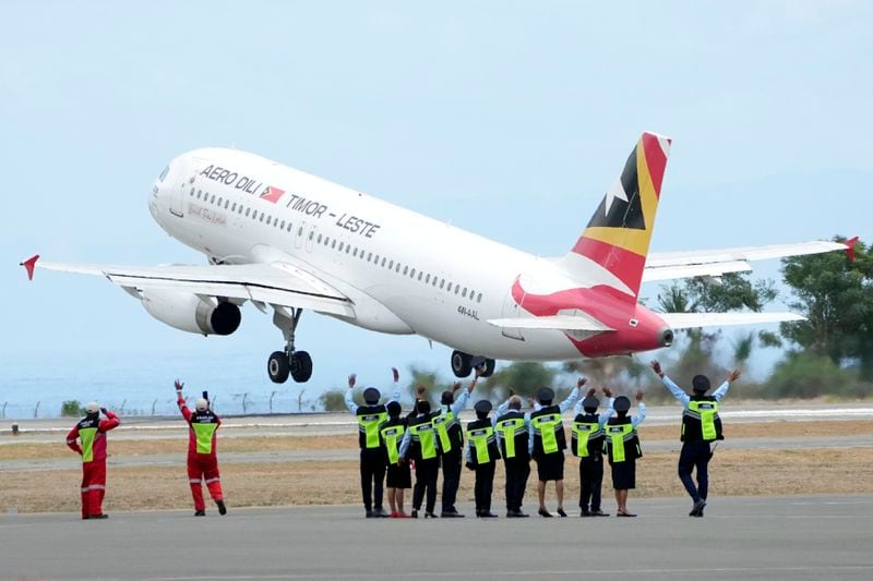 Airport staff wave to an airplane which Pope Francis aboard at Nicolau Lobato International Airport in Dili, East Timor, Wednesday, Sept. 11, 2024. (AP Photo/Dita Alangkara)