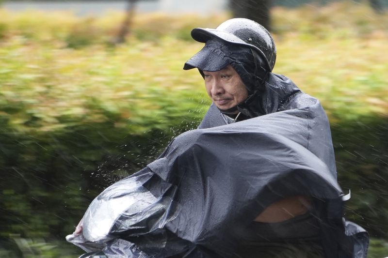 A man rides a motorcycle in the rain caused by typhoon Yagi in Hanoi, Vietnam Saturday, Sept. 7, 2024. (AP Photo/Hau Dinh)