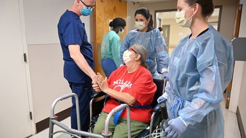 Glenda Bailey, a Miller County resident who was sick with COVID-19, expresses her thanks to Dr. Bill Swofford (left) as she is assisted by medical staff Carmen Lambert and Jamie Middleton (right) at Miller County Hospital in Colquitt. (Hyosub Shin / Hyosub.Shin@ajc.com)