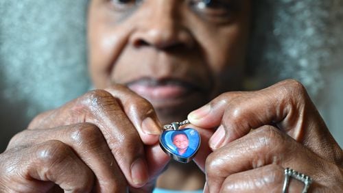 Glenda Mack holds a necklace that includes a photo of her grandson David. The 12-year-old was found shot to death in February, not far from their southwest Atlanta home.