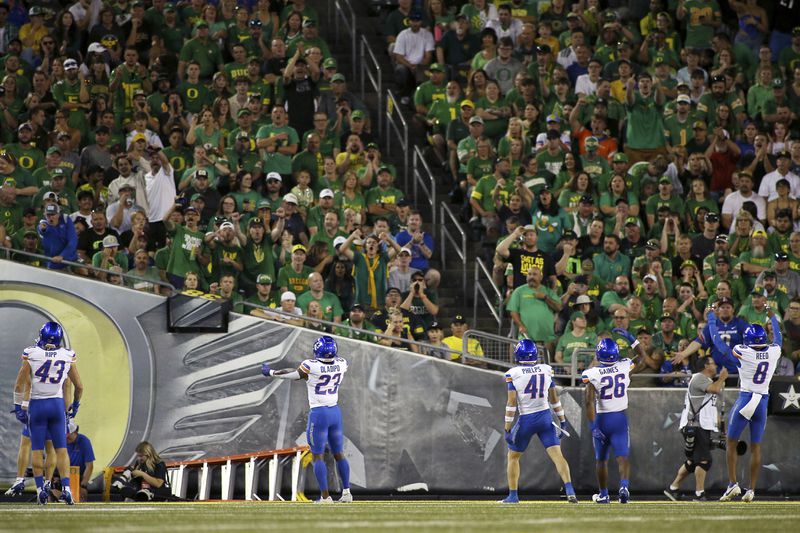 Boise State linebacker Jake Ripp (43), safety Seyi Oladipo (23), safety Boen Phelps (41), running back Sire Gaines (26) and cornerback Markel Reed (8) interact with the crowd during the first half of an NCAA college football game, Saturday, Sept. 7, 2024, at Autzen Stadium in Eugene, Ore. (AP Photo/Lydia Ely)