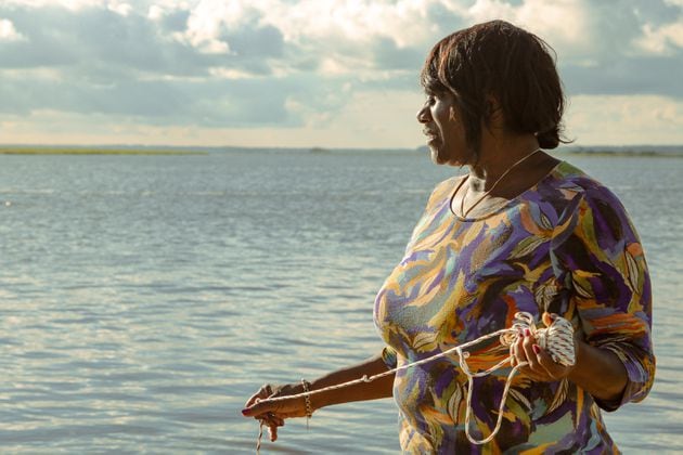 Chef Sallie Ann Robinson expertly throws her crab net into the water, blending skill with heritage as she gathers fresh crabs for her signature dish, Ol' 'Fuskie Fried Crab Rice. (Adriana Iris Boatwright for the Atlanta Journal-Constitution)