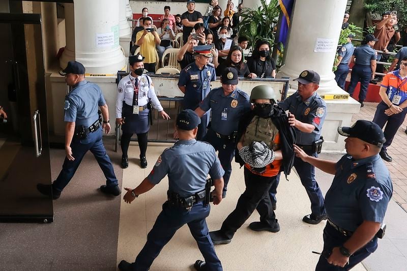 Apollo Carreon Quiboloy, wearing a helmet and flak jacket, a Filipino preacher charged with human trafficking, enters the Pasig Regional Trial Court in Pasig City, Philippines, Friday, Sept. 13, 2024. (AP Photo/Gerard Carreon)